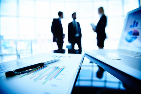 Tech Businessmen standing behind laptop