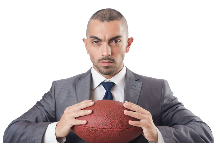 angry business guy holding football wearing a suit