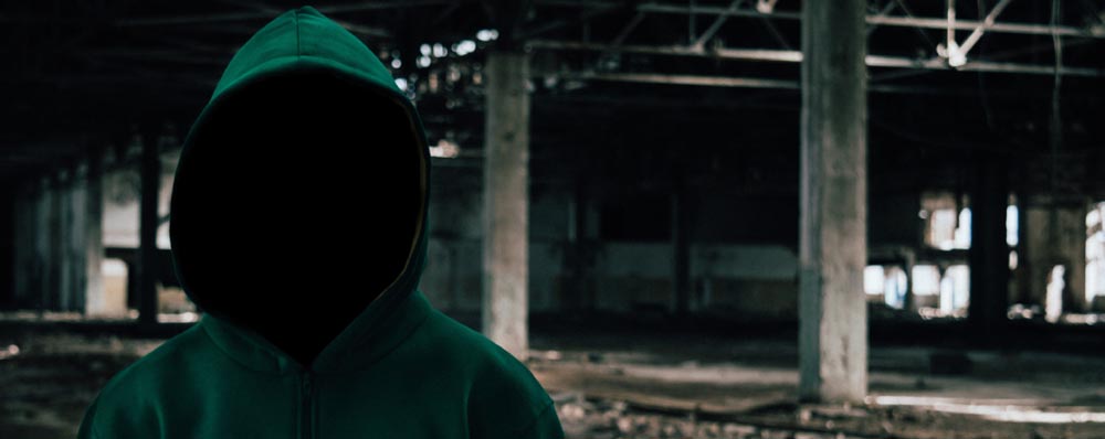 dark alley with faceless man in hoodie