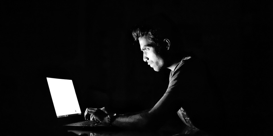 Man in dark on laptop