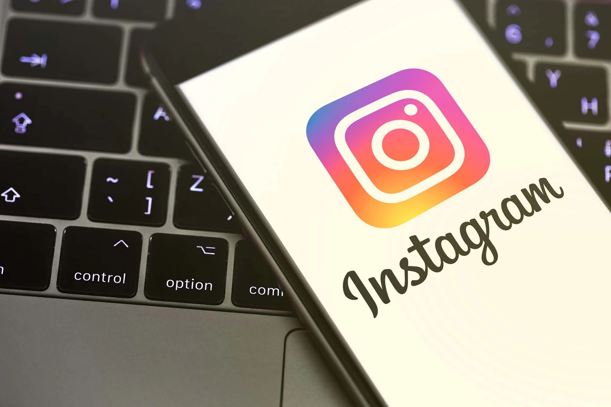 Image of a smartphone laying on computer keyboard with instagram app launching