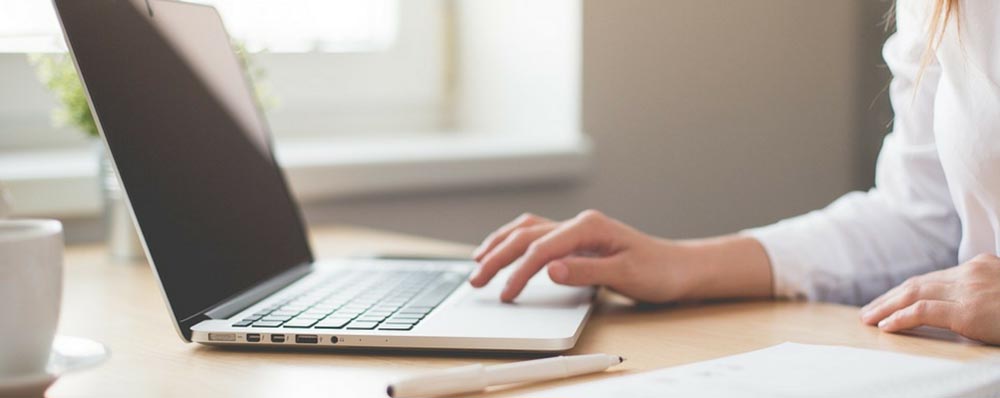 woman dragging finger on trackpad of laptop