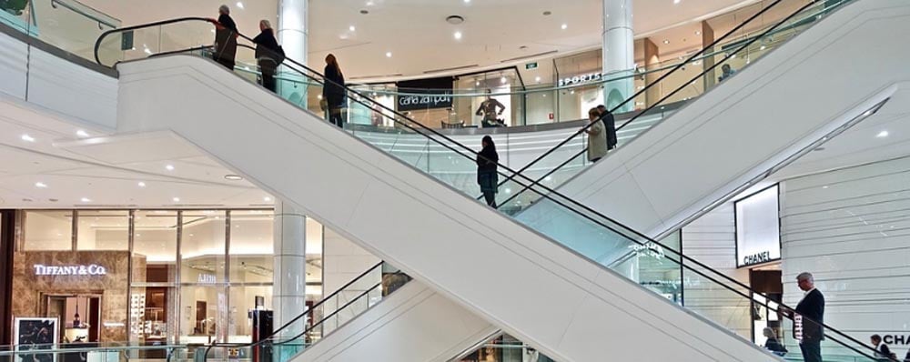 people going up and down escalators in shopping mall