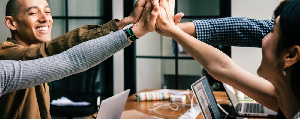 people joining hands at conference room table