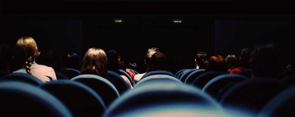 backs of people sitting in movie theater
