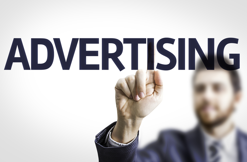man pointing to the word advertising