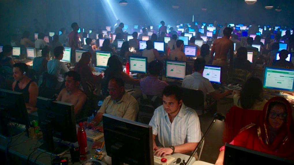 people crammed into a room all on computers